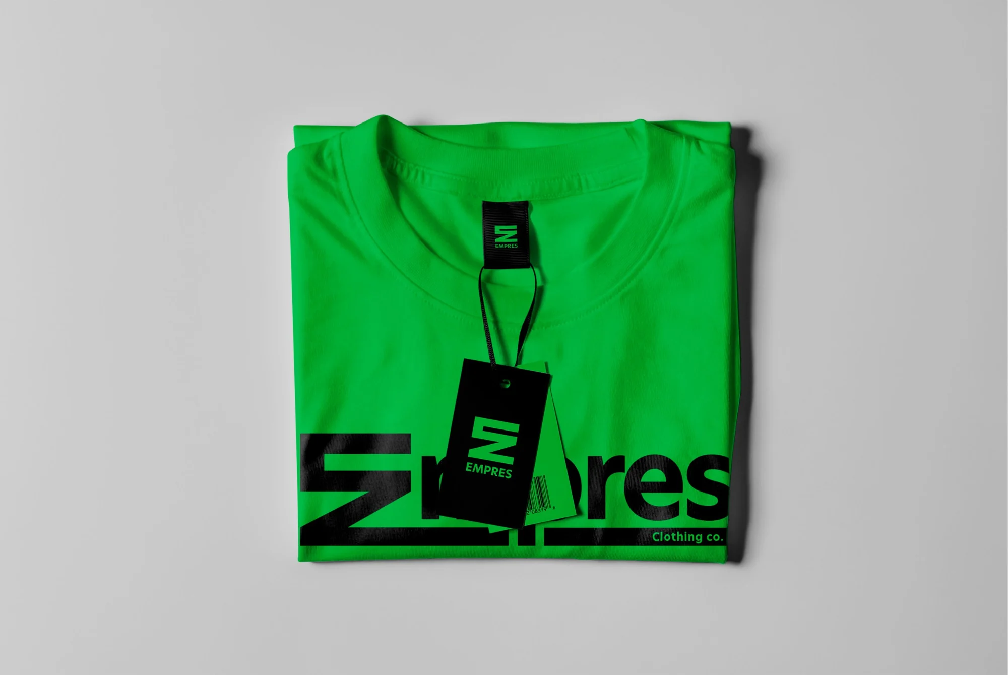 Folded green Empres tee with a black woven neck label and a black hang tag with the green stacked logo